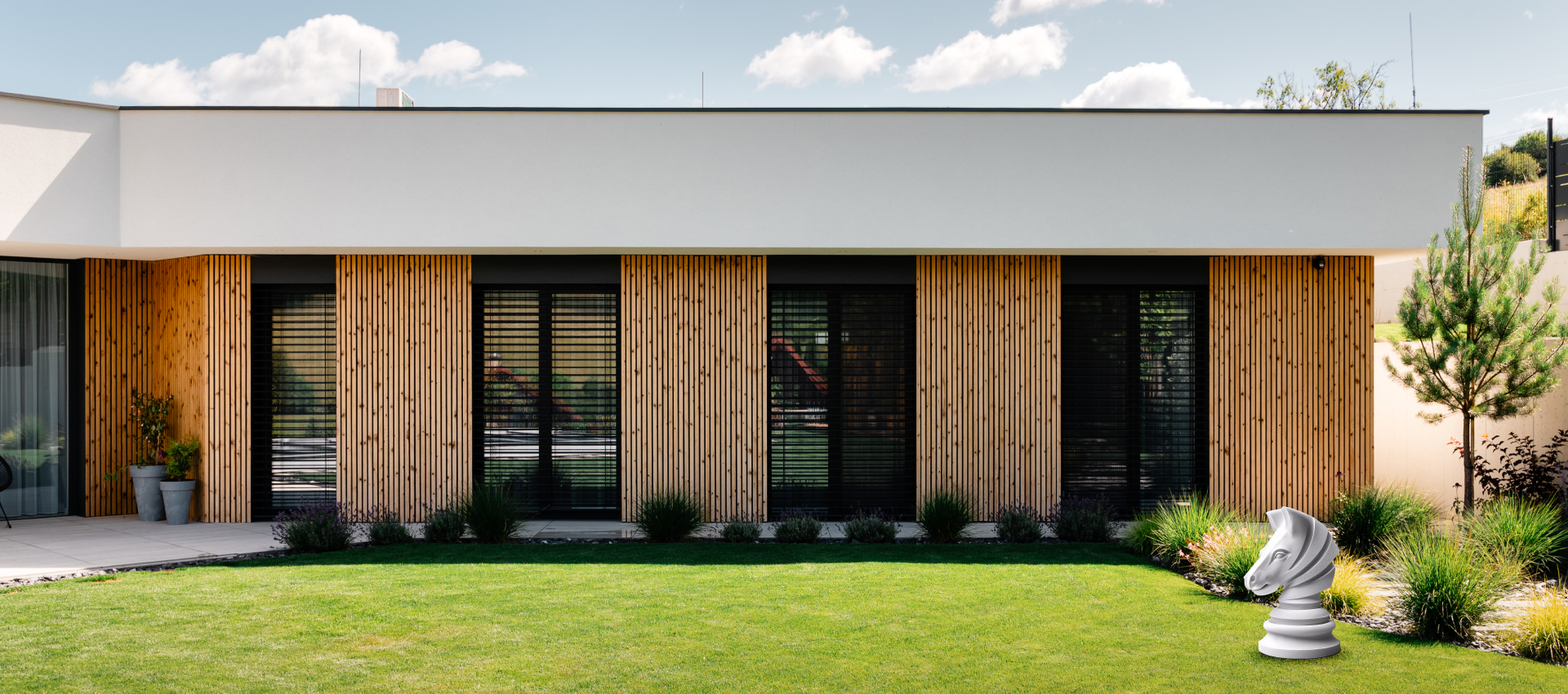 Fasáda rodinného domu s vonkajšími žalúziami a dreveným obkladom